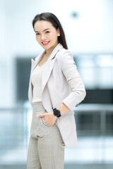 Happy confident businesswoman in beige suit smiling in modern office, showing ambition, positivity,...