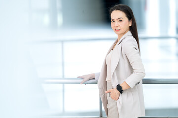 Professional Asian woman in elegant beige suit posing indoors, symbolizing success, ambition, and...