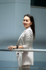 Professional Asian woman in beige suit smiling with trust and confidence, symbolizing leadership...