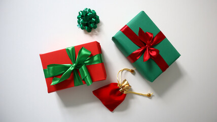 Creative Christmas composition on white background, featuring two festively wrapped gifts, red one...