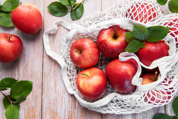 Fresh red apples in reusable shopping bag promoting sustainable lifestyle