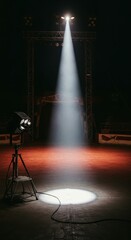 A spotlight illuminates the center of a dark performance venue, casting a bright circle of light on the stage floor.