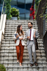 Business people walking down stairs while talking about work
