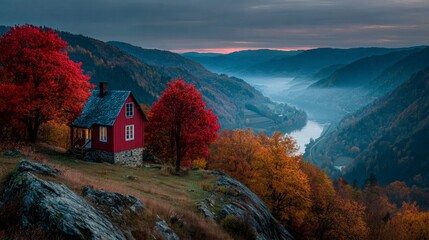 Naklejka premium Red wooden cabin overlooking misty valley in autumn