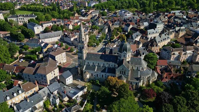 High aerial orbit of Notre-Dame de Ch&acirc;teauroux and nearby town in clear daylight conditions