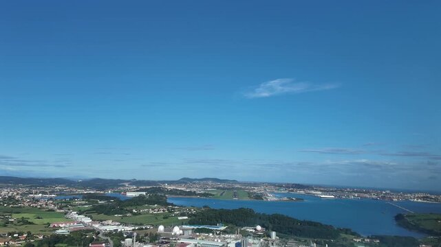 An immersive pilot&rsquo;s eye FPV aerial view taken from a jet cocklpit in a real time approach to Santander airport runway, overflying the bay, in a quiet sunny summer morning, unclouded sky