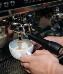 Barista pulling espresso shot into white cup
