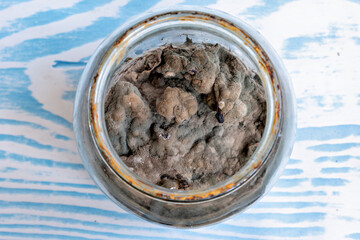 A glass jar with a metal lid containing what appears to be a substance that looks like dirt or soil