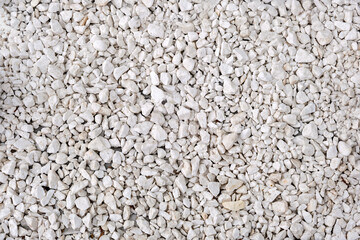 This image shows a close-up view of a surface covered with small irregularly shaped white rocks or pebbles
