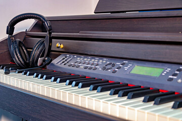 This image shows a musical keyboard which appears to be an electric piano or keyboard placed on a piano