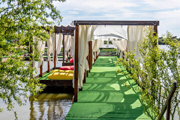 This image shows a serene outdoor setting with a wooden structure that appears to be a gazebo or pavilion
