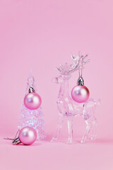 Christmas card on which a beautiful transparent Christmas tree is decorated with pink balls by a transparent deer, pink background, vertical, creative focus