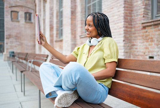 Young woman using tablet while sitting on bench