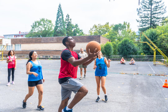 Basketball players shooting and playing on outdoor court - Powered by Adobe