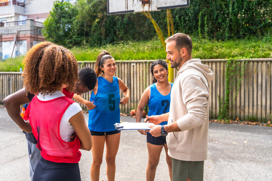Basketball coach giving instructions to female players during training - Powered by Adobe