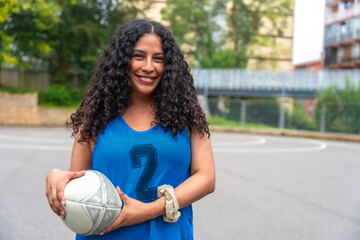 Confident rugby player holding ball on outdoor court