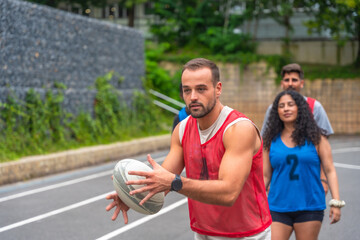 Rugby player passing ball during training with teammates outdoors