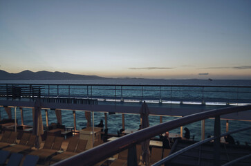 Obraz premium Pooldeck or swimmingpool with sun deck on modern cruiseship or cruise ship liner with elegant lounge furniture deck chairs and rattan sun beds loungers