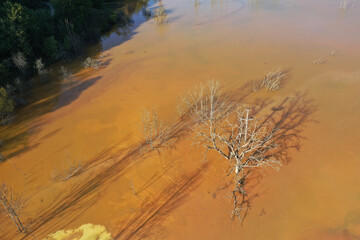 Abstract natural colorful patterns of acid mine drainage in decanting lake aerial view