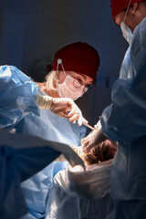 Professional surgeons performing a dental operation in a clinical environment