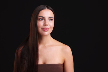 Woman with beautiful smooth hair after lamination procedure on black background