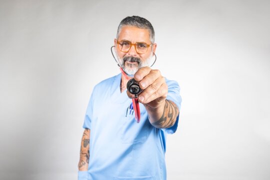Doctor showing stethoscope wearing light blue scrubs and glasses