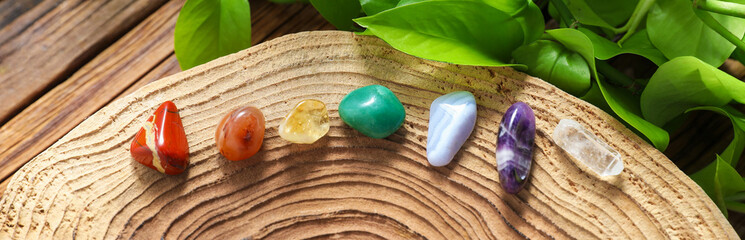 Aura. Different natural mineral stones and green leaves on wooden table, flat lay