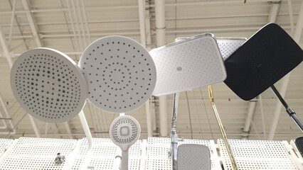 Assorted modern showerheads displayed on rack in store interior
