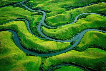 Obraz premium Winding river meanders through lush green hills