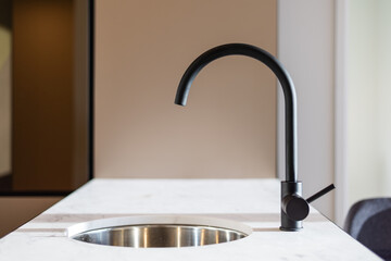 Close-up of sink built into island in modern home kitchen