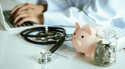 A stethoscope with coins, jar, and piggy bank represents saving money, healthcare costs, insurance, investment, financial planning, and economic security.