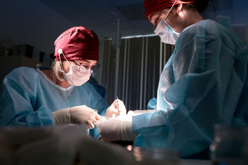 Surgeons performing precise medical operation in a well-lit surgical room