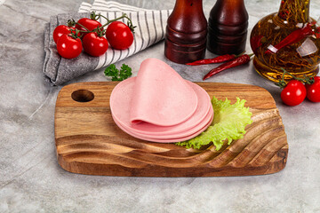 Sliced boiled sausage over board