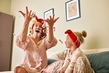 Mother and daughter enjoying playful moments together in a cozy home
