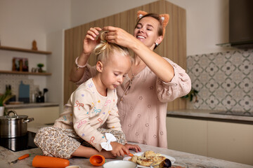 Mother braiding her daughter's hair in a cozy and clean kitchen setting