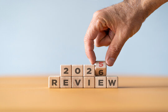 Hand flipping of 2025 to 2026 on wooden blocks. 2025 business and customer review for business strategic planning in the next year 2026. End of the year business concept.