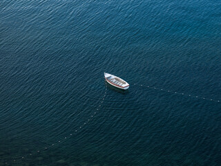 Small white boat in the middle of the lake