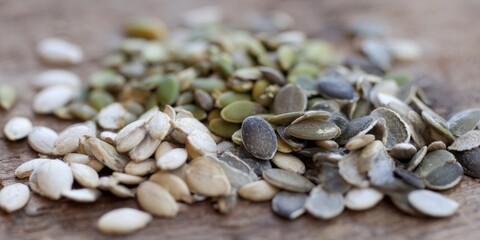 Obraz premium A close-up shot showcasing a mix of healthy pumpkin seeds on wood.