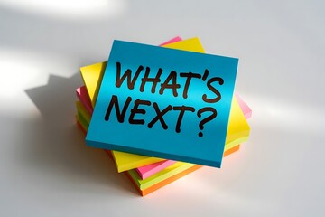 A stack of colorful sticky notes with the question what s next written in bold black letters on the top blue note
