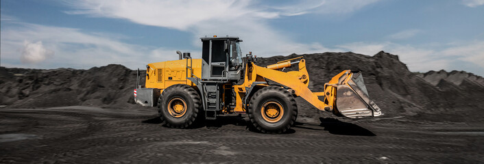 Loading of an loader into railway wagons. Excavator loading coal into wagons. Loading of coal truck using excavator. Shipment coal for transportation by rail
