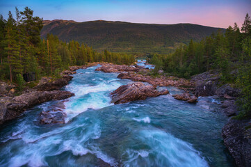Sunset view of Pollfoss waterfall on the Framruste River near Billingdalen, Oppland, Norway.