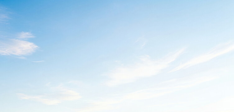 Bright blue sky filled with soft white clouds, featuring a subtle gradient effect, creating a peaceful and airy atmosphere with natural soft light and calm scenic backdrop.