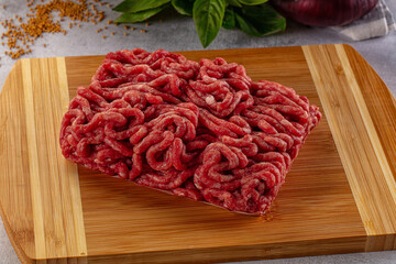 Raw minced beef meat over board