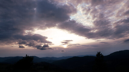 Evening natural landscape in the mountains with voluminous clouds