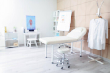 Blurred view of medical office with couch and doctor's workplace