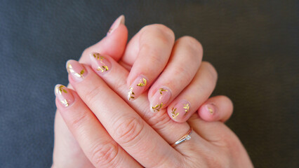 Great manicure, close-up photo. Female hands on a dark background.