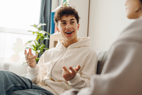 Teenager with braces talking with psychologist during therapy session