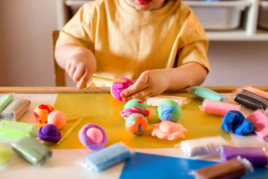 Child Playing with Colorful Modeling Clay at Home