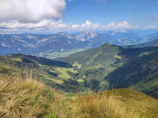 Panoramic View of Green Alpine Valley and Distant Mountain Range