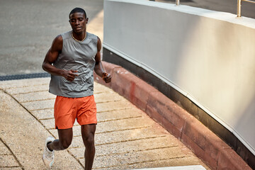 Man jogging outdoors on a sunny day with an urban background